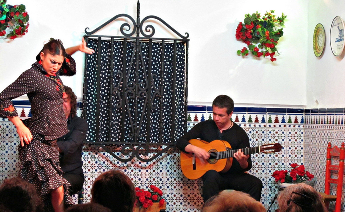 Flamenco dancer and guitarist performing in a small venue.